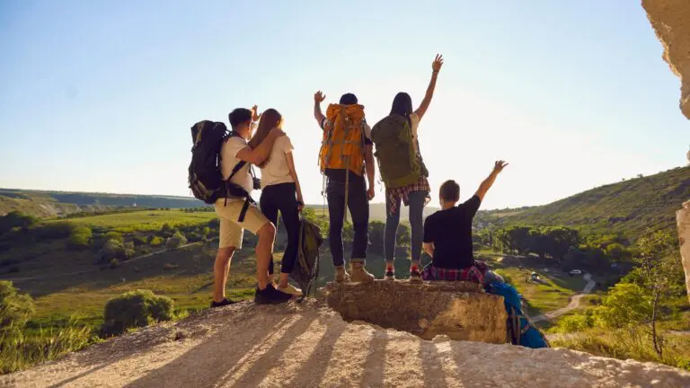Group of hikers celebrating on a hilltop at sunset