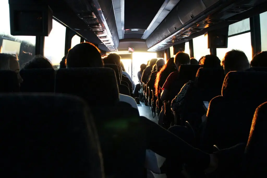 Group travelers seated inside a tour bus during sunset