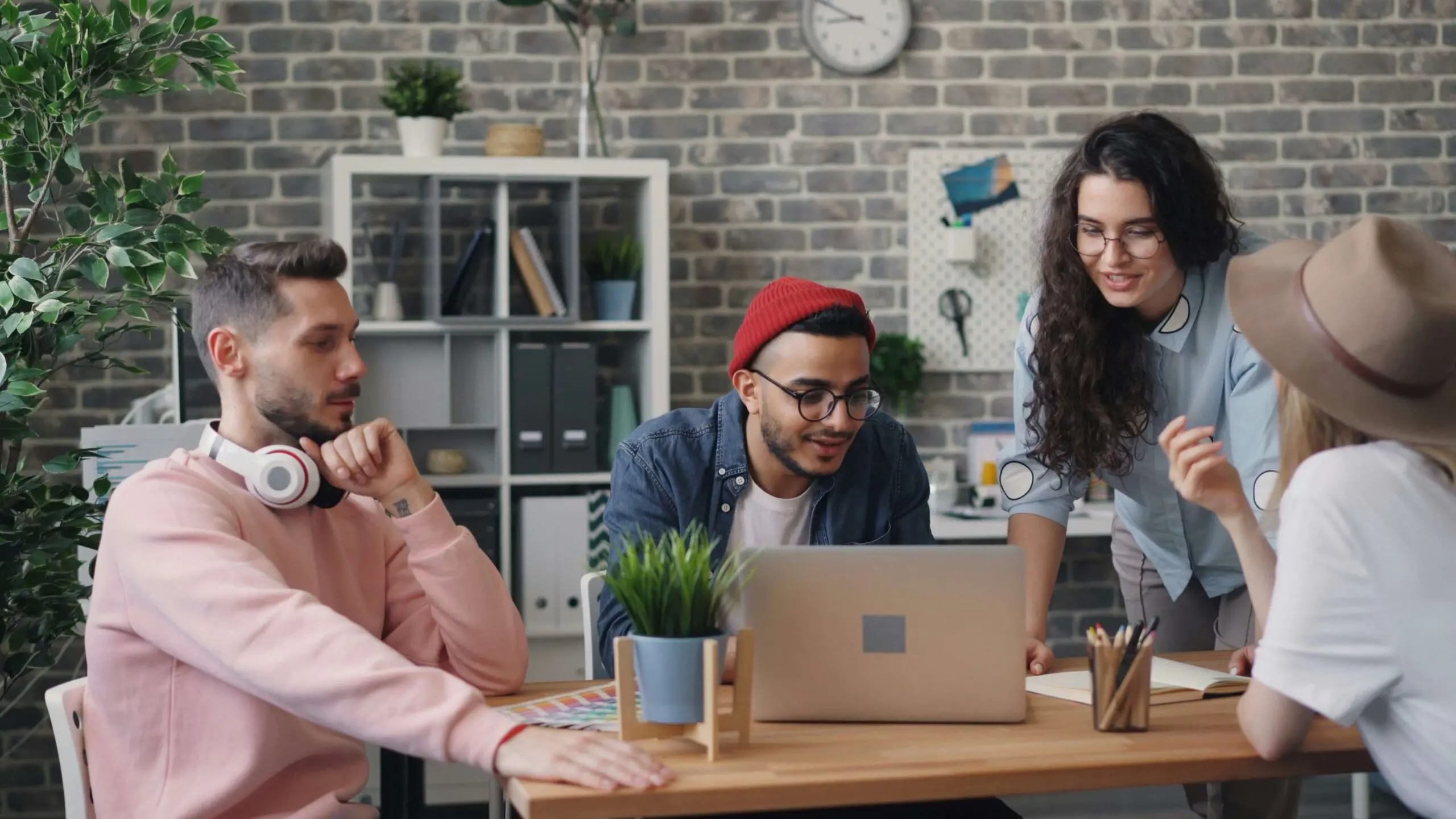 Group of tour professionals collaborating around a laptop in a modern office